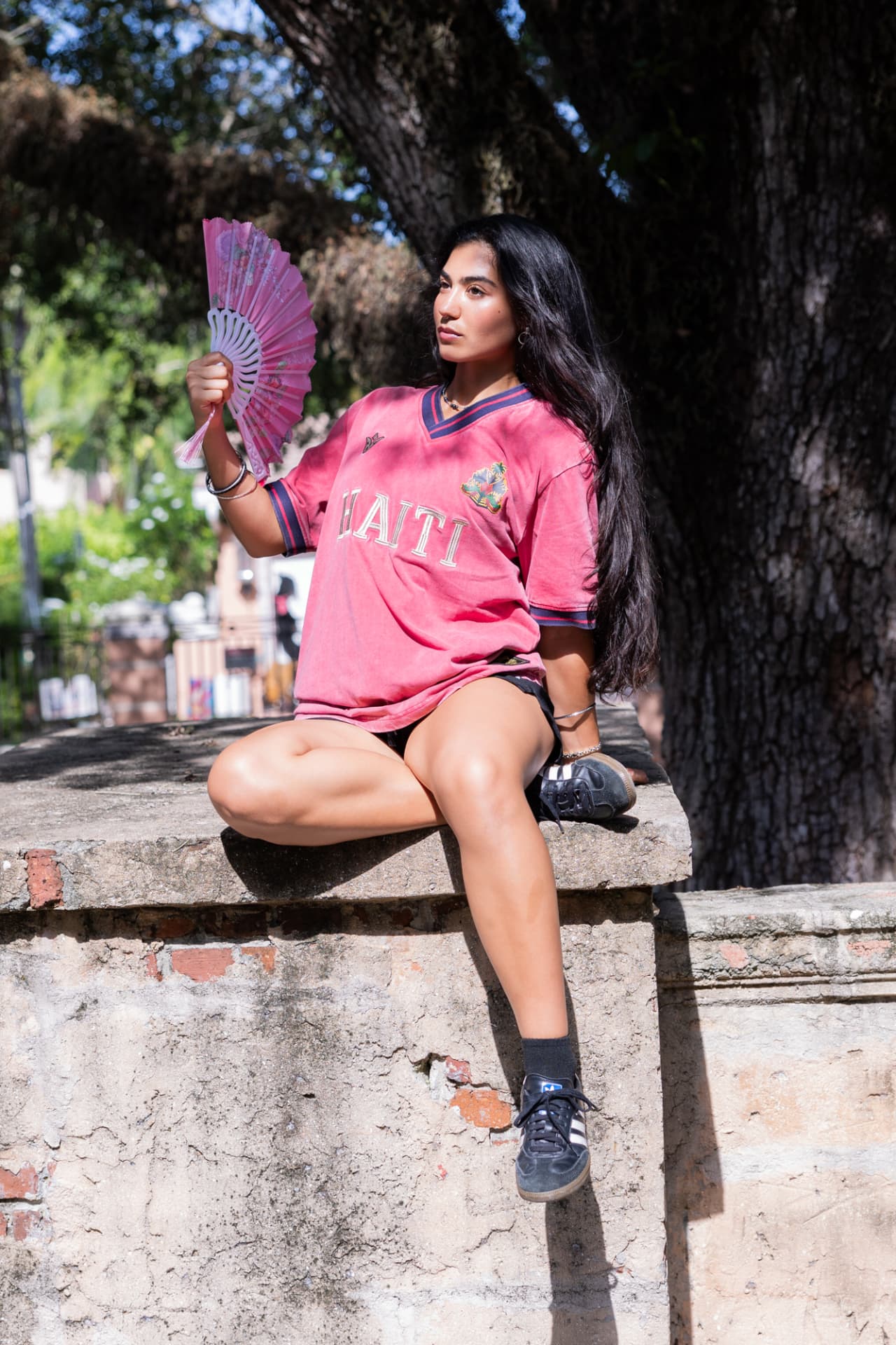Dusty rose polo seated with fan